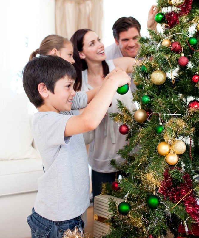 10222263 - happy family decorating a christmas tree with boubles