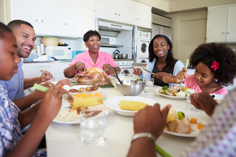 31066927 - multi-generation family sitting around table eating meal