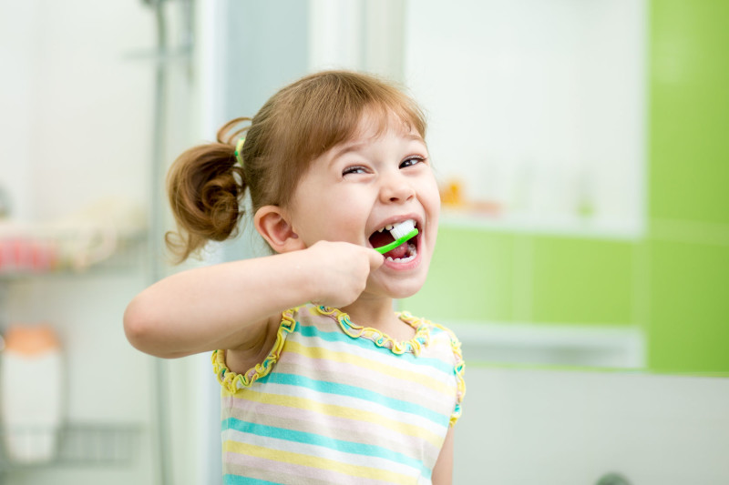 33255497 - funny child girl brushing teeth in bathroom