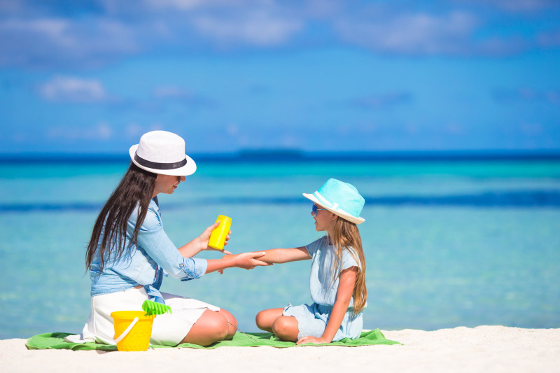 39665952 - young mother applying sunscreen on her kid