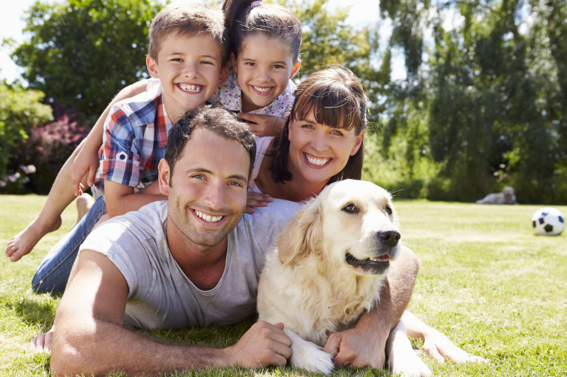 42309403 - family relaxing in garden with pet dog
